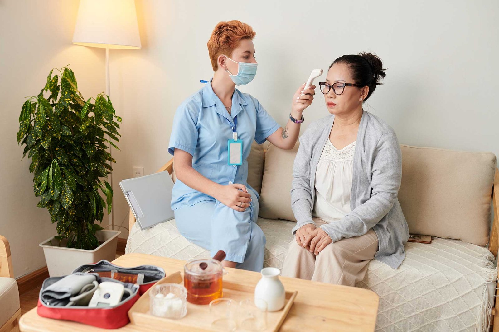Qualified nurse conducting friendly health check at home